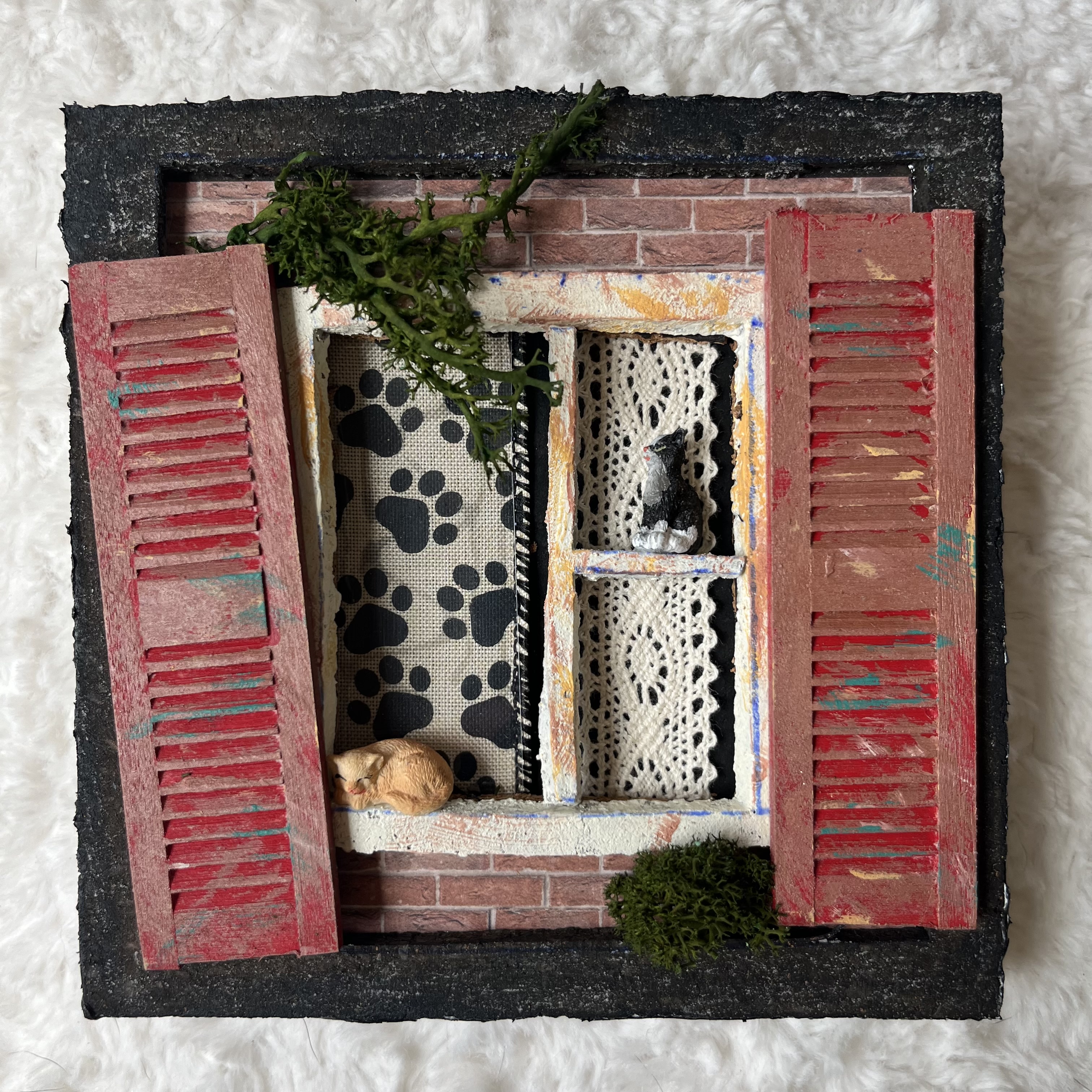 Miniature window scene with two cats and whimsical shutters