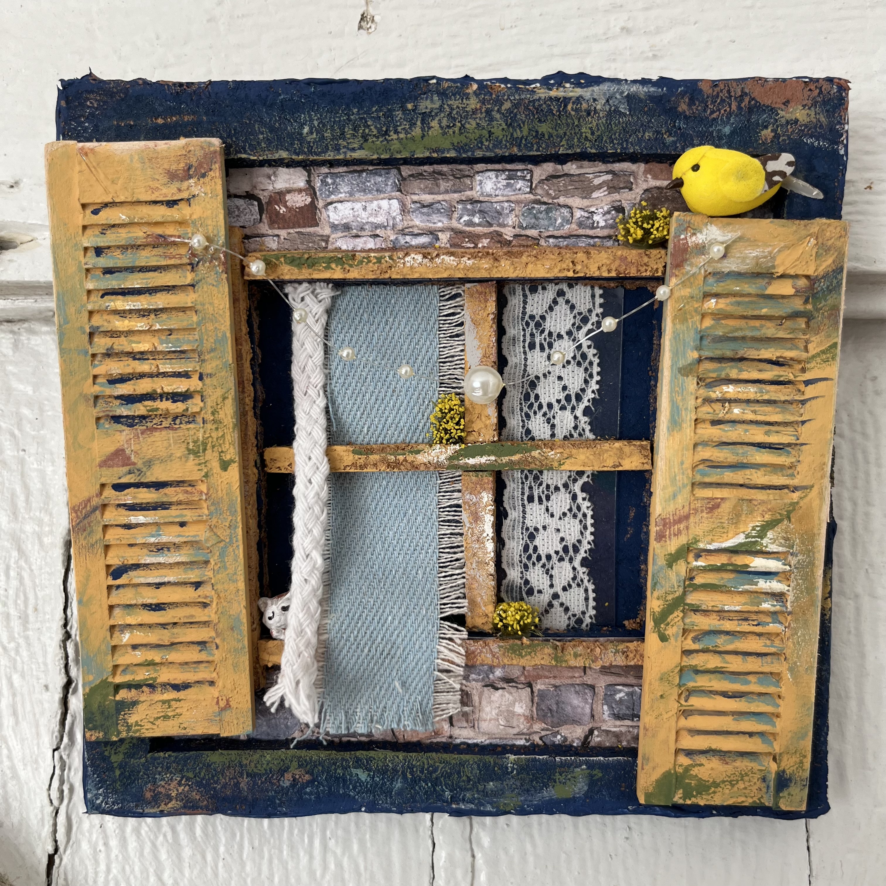 Miniature window scene with a sleepy cute cat, bird, and faux stonework